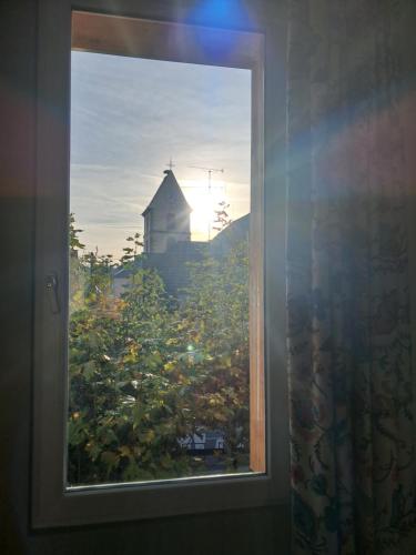 a window with a view of a house and a barn at Hôtel du Cheval Blanc Brunstatt in Brunstatt