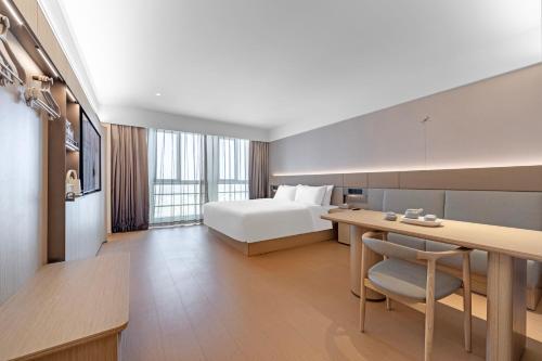a hotel room with a bed and a desk at JI Hotel Shanghai Pudong International Airport Huinan in Shanghai
