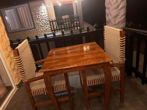 a wooden table and chairs in a room at Hotel RaptiRiverview in Khargauli