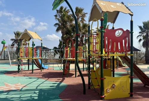 a playground in a park with a slide at Mobile home in Sérignan