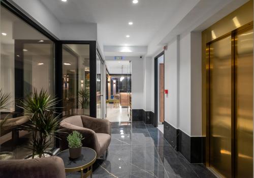 a lobby with chairs and a table in a building at Captain Napoleon Paterakis CNP Luxurious Suites in Heraklio
