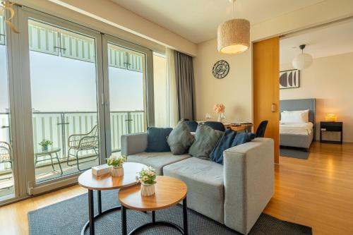 salon z kanapą i dużym oknem w obiekcie Stylish 1BR Retreat Al Sana, Al Raha Beach w Abu Zabi