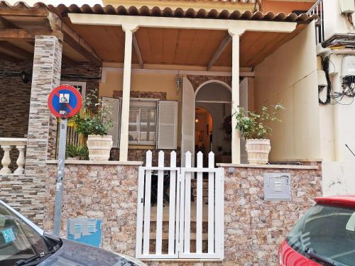 a white gate in front of a house at Casita Arenal in El Arenal