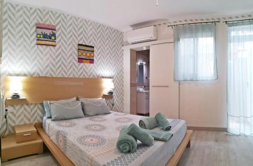 a bedroom with a bed with green towels on it at Casita Arenal in El Arenal