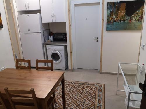- une cuisine avec une table et un lave-linge/sèche-linge dans l'établissement Allenby2, à Jérusalem