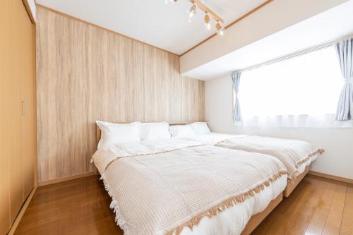 a bedroom with a large bed with a window at Ayame Building in Tokyo