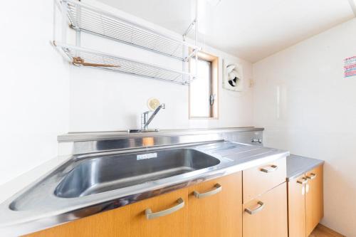 a kitchen with a stainless steel sink and a window at Ayame Building in Tokyo