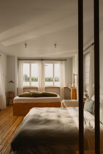 two beds in a bedroom with a window at La Maison Plûme in Villequier