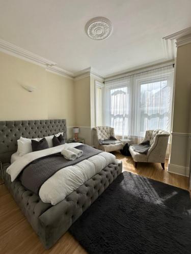 a large bedroom with a large bed and two chairs at 5 min from the beach O2 academy shared bathroom and kitchen in Bournemouth