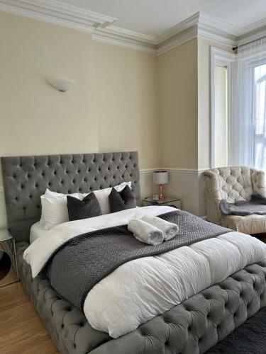 a bedroom with a large bed with a gray headboard at 5 min from the beach O2 academy shared bathroom and kitchen in Bournemouth