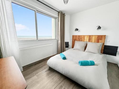 a bedroom with a large bed with a large window at Vue mer imprenable à Dunkerque, l'appel du large! in Dunkerque