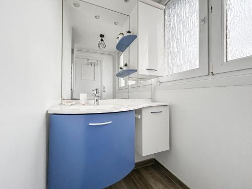 a bathroom with a blue cabinet and a sink at Vue mer imprenable à Dunkerque, l'appel du large! in Dunkerque