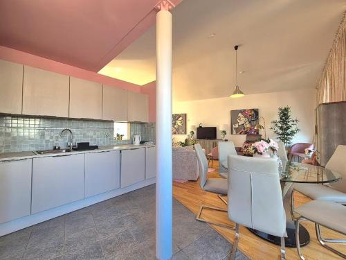 Una cocina y sala de estar con gabinetes blancos y una mesa. en Enjoy a stylish experience at this centrally-located place !, en Dublín