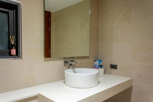 Un baño con un lavabo blanco y un espejo. en Villa Seaview Majestic, en Chaweng Noi Beach