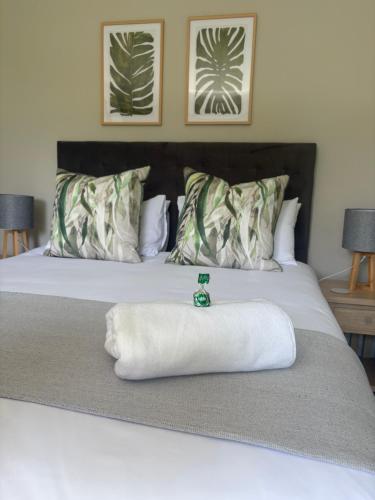 a bed with a white towel on top of it at Serenity Luxury Guesthouse in Krugersdorp
