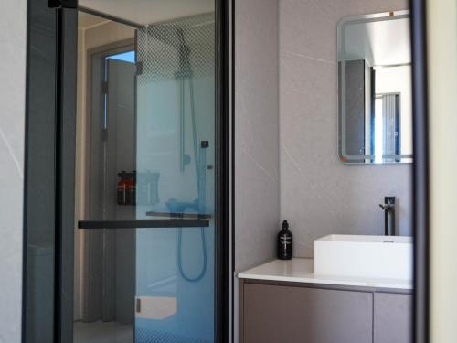 a bathroom with a glass shower and a sink at Aravina Escapes in Yallingup Siding