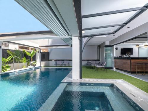 an indoor swimming pool in a house with a kitchen at Captain Napoleon Paterakis CNP Luxurious Suites in Heraklio