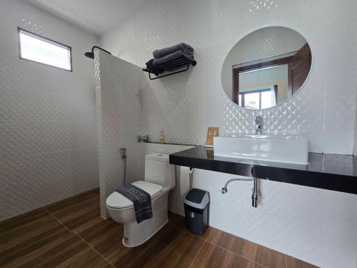 Un baño con inodoro, lavabo y espejo. en TiTIME POOL VILLA, en Ao Nang 