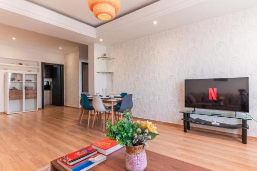 a living room with a television and a table at Appartement Cosy et central in Casablanca