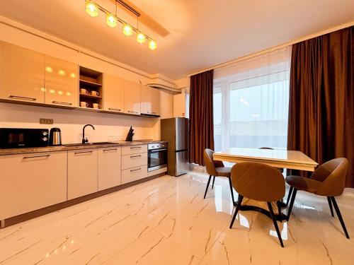 une cuisine avec une table et des chaises ainsi qu'une salle à manger dans l'établissement Julia Airport Apartment With Parking, à Someşeni