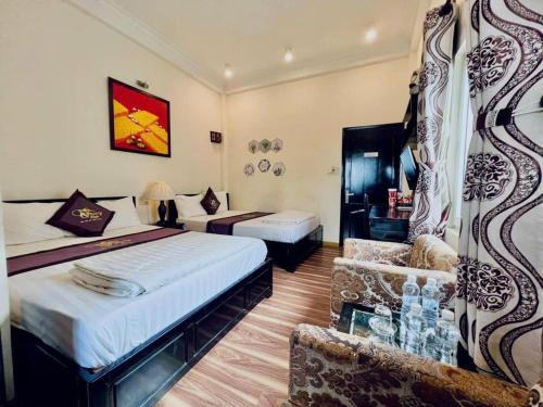 een hotelkamer met twee bedden en een stoel bij Canary Boutique Hotel in Hue
