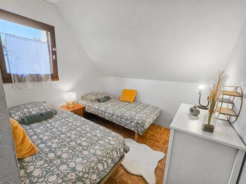 a small room with two beds and a window at Maison paisible avec jardin à Houlgate in Houlgate