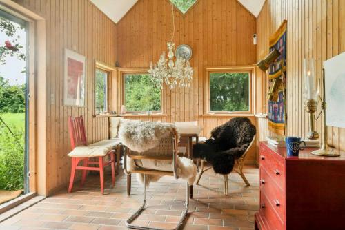 a dining room with a table and chairs and a chandelier at Quiet Hideaway Surrounded By Nature in Vesterborg