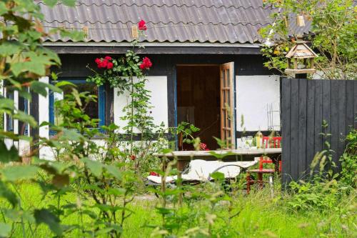 a small house with a table and a fence at Quiet Hideaway Surrounded By Nature in Vesterborg