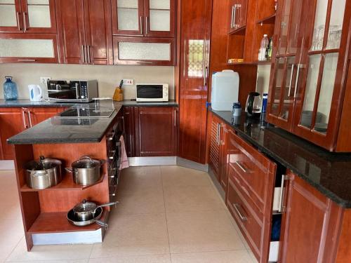 a kitchen with wooden cabinets and a counter top at Family Home In Maun in Maun