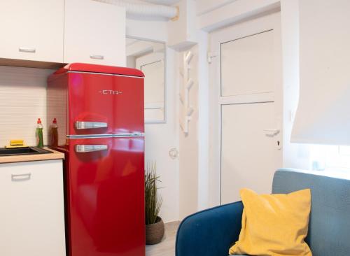 a red refrigerator in a kitchen with a blue chair at Secluded Studio in Central Sesvete in Sesvete