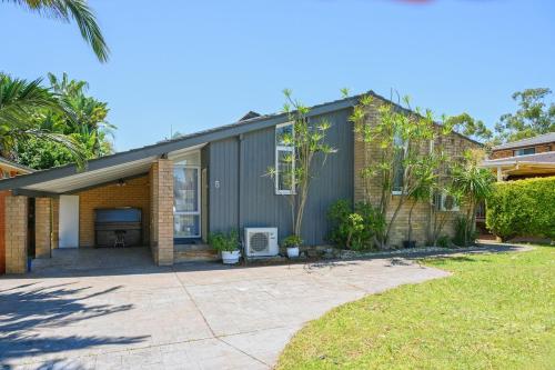 a house with a garage and a driveway at Casula cozy 3Br home with parking & WiFi 
