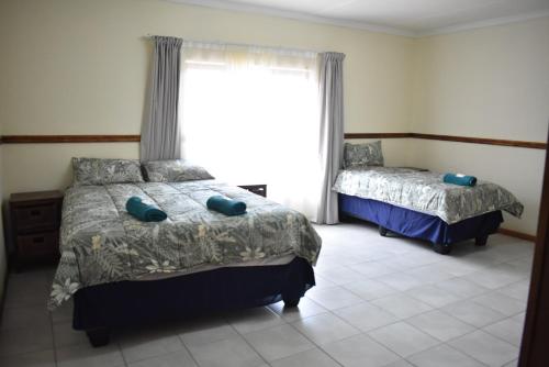 Un dormitorio con dos camas y una ventana en 41 on Clarendon, en Graskop