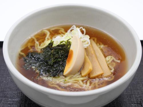 a bowl of noodle soup with a lemon in it at Dormy Inn Wakkanai in Wakkanai