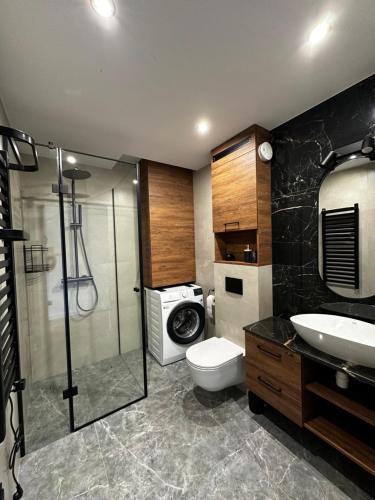 a bathroom with a shower toilet and a sink at Verde Klon Apartment- Lotnisko Jasionka in Jasionka