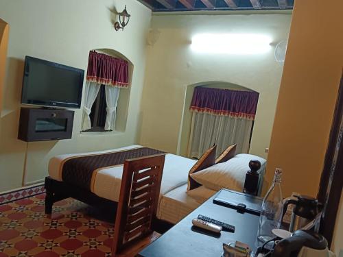 Un televizor și/sau centru de divertisment la Kovilakam the heritage resort Ethannur,Palakkad