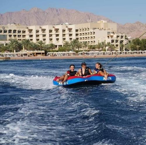 three people riding on a raft in the water at aqaba Almahdud in Aqaba