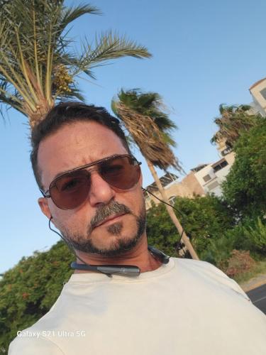 a man wearing sunglasses and a bow tie at aqaba Almahdud in Aqaba