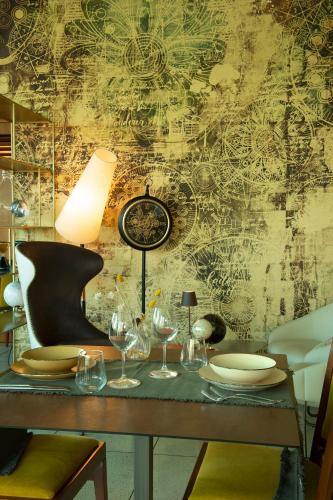 een tafel met wijnglazen en een klok aan de muur bij Castagna Palace Hotel & Restaurant in Montecchio Maggiore