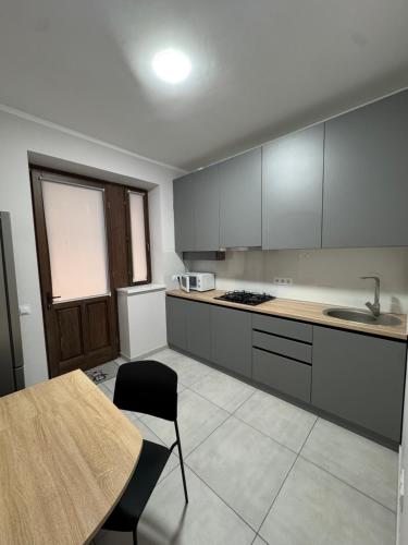 a kitchen with a wooden table and a table and a table and chairs at Apartment Balti Centru in Bălţi