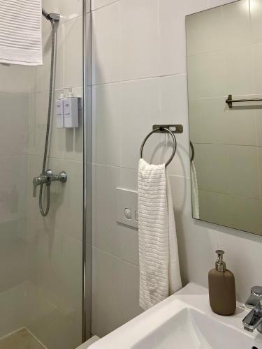 a bathroom with a shower and a sink and a mirror at JC Apartments in Amadora