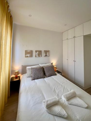 a bedroom with a large white bed with two pillows at JC Apartments in Amadora