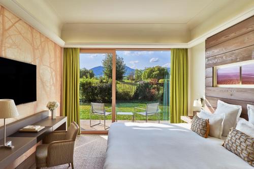 a hotel room with a large bed and a large window at Hôtel Barrière Ribeauvillé in Ribeauvillé