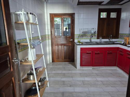 een keuken met rode kasten en een rode deur bij Nur Nur House in Ban Nong Chaeng