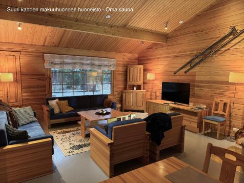 een woonkamer met houten lambrisering en een televisie bij Messner Tahko in Tahkovuori