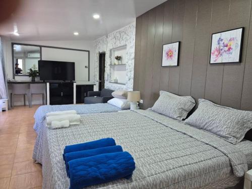 een slaapkamer met een groot bed met blauwe kussens bij Nur Nur House in Ban Nong Chaeng