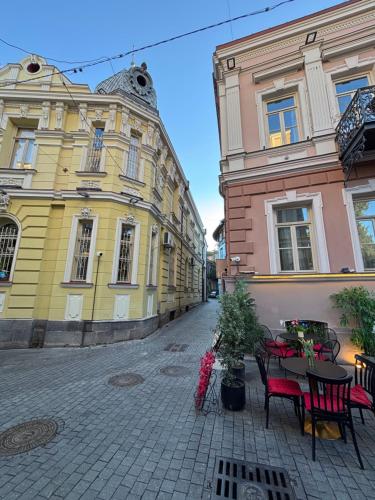 an empty street with tables and chairs in front of buildings at Corner Guest House in Tbilisi City