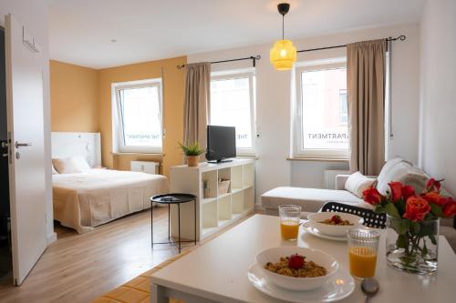 a living room with a bed and a table with food at Kaisercity Apartment 2 in Nuremberg