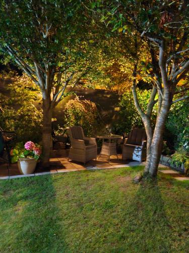 a yard with two chairs and a table under two trees at Knightsbrook Guesthouse in Trim