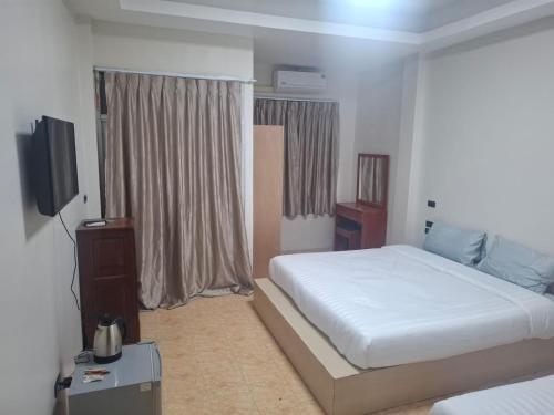 Een bed of bedden in een kamer bij Kami Guest House Patong