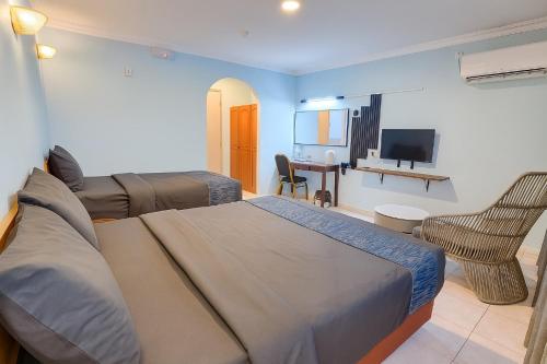 ラブアンにあるNeela Houseのベッド、ソファ、テレビのある寝室